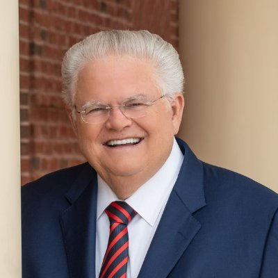 Pastor John Hagee in a blue coat smiling broadly