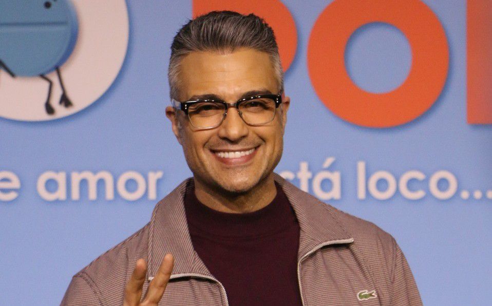 Jaime Camil smiling on camera while doing a peace sign