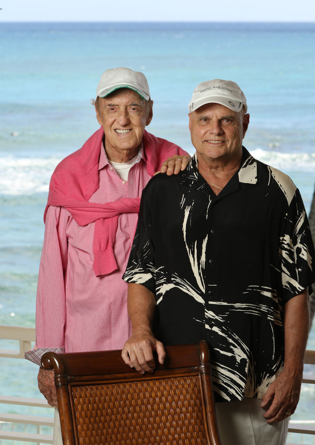 Stan Cadwallader and Jim Nabors standing in a balcony, with the beach at their back