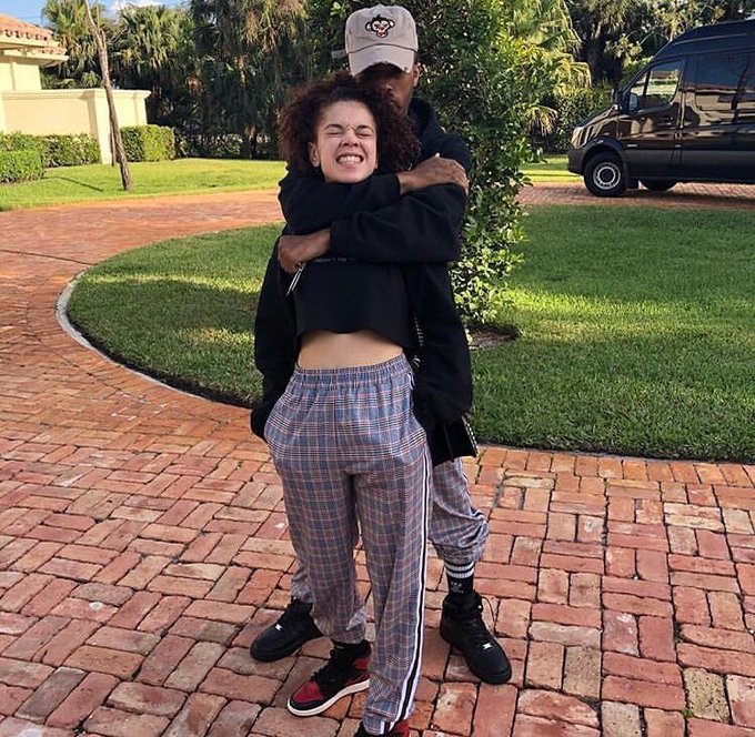 Jenesis Sanchez grins with eyes closed as XXXTentacion hugs her from behind outside his Parkland mansion in Florida