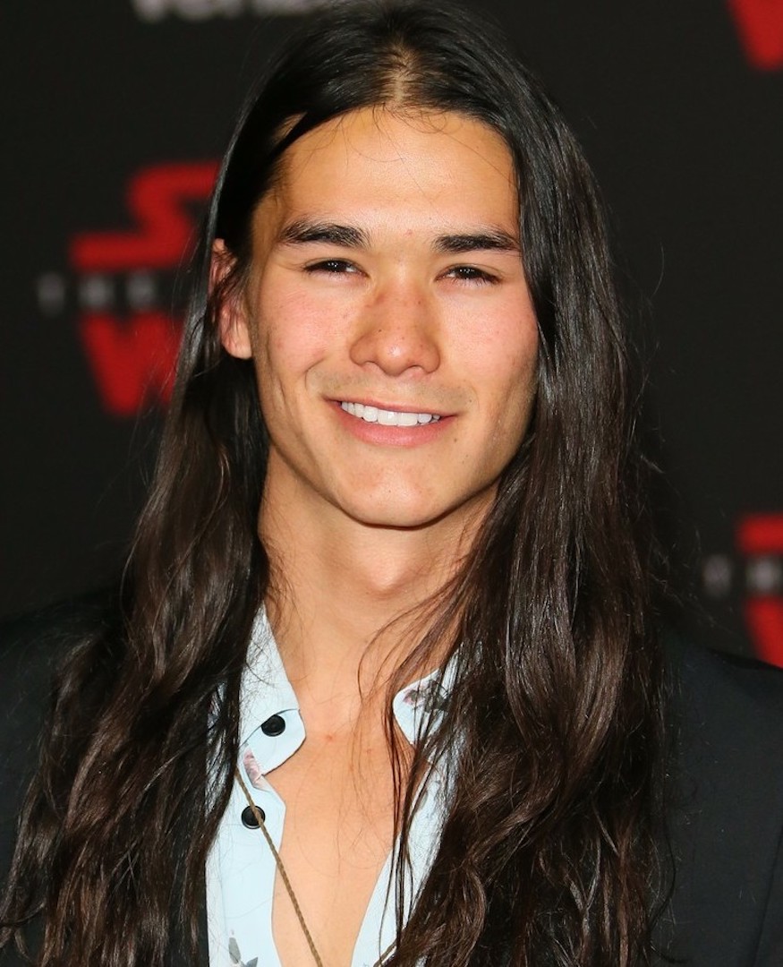 Booboo Stewart wearing formal attire and showing off his long hair