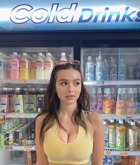 Sophie Mudd standing infront of fridge with different types of bottled drinks