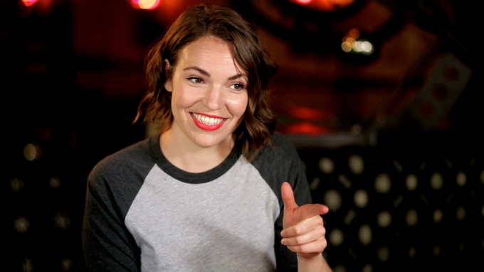 Beth Stelling wearing a long-sleeve shirt while pointing her forefinger at something