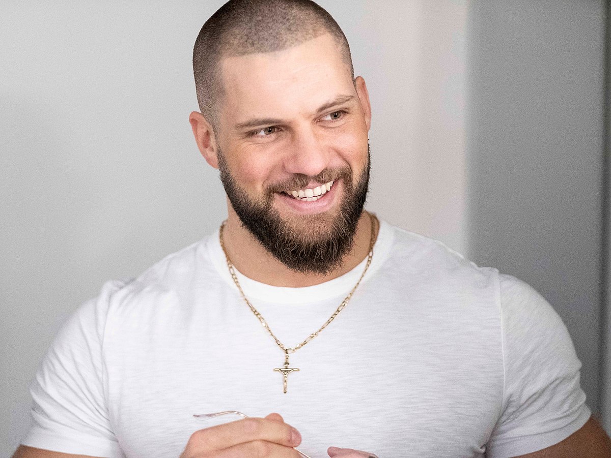 Florian Munteanu wearing a tight white t-shirt and a cross necklace
