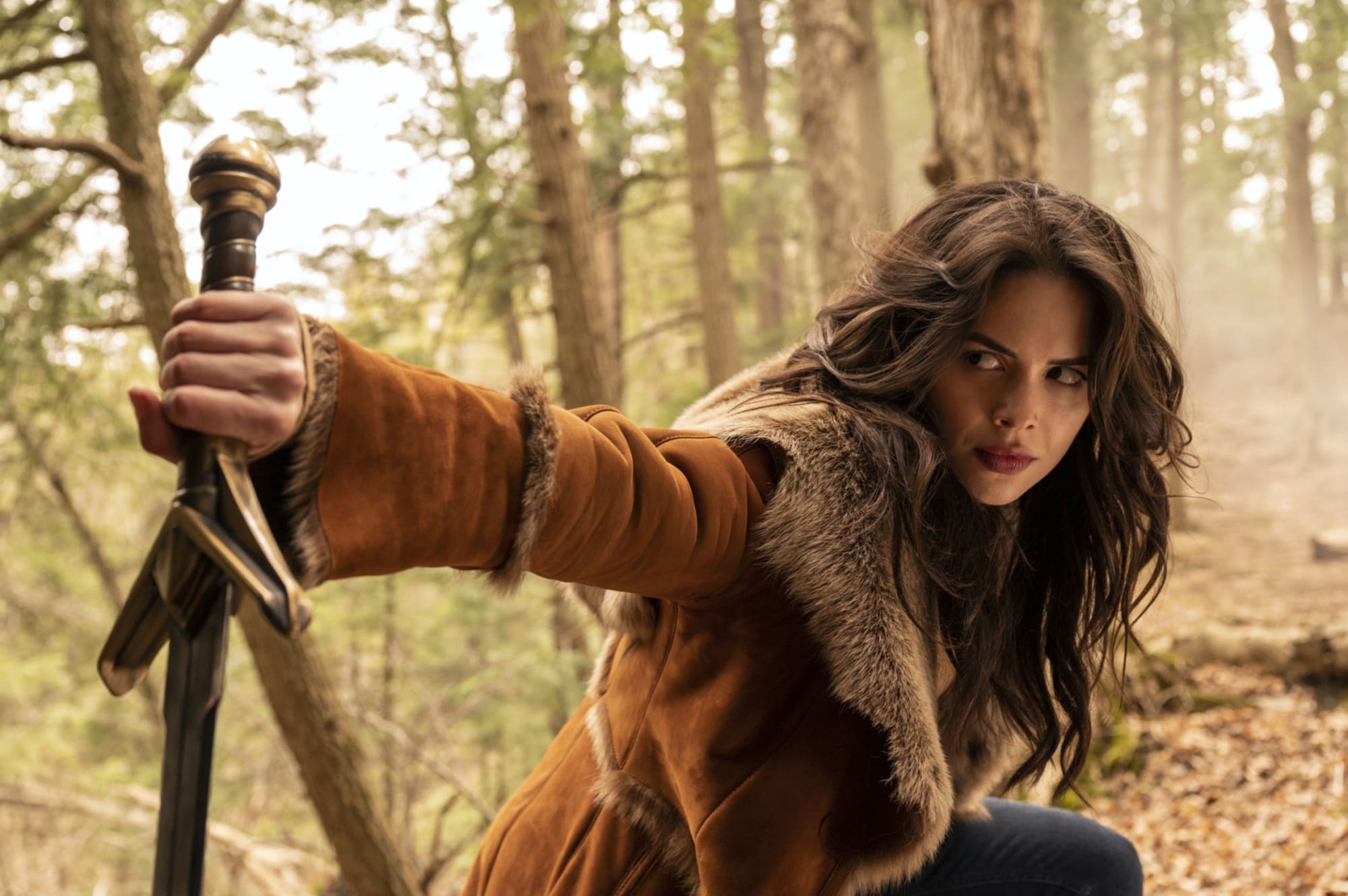 Conor Leslie as Donna Troy in 'Titans' wearing burnt orange coat and holding a sword