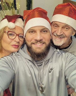 A selfie of Florian Munteanu with his parents while wearing Santa hats