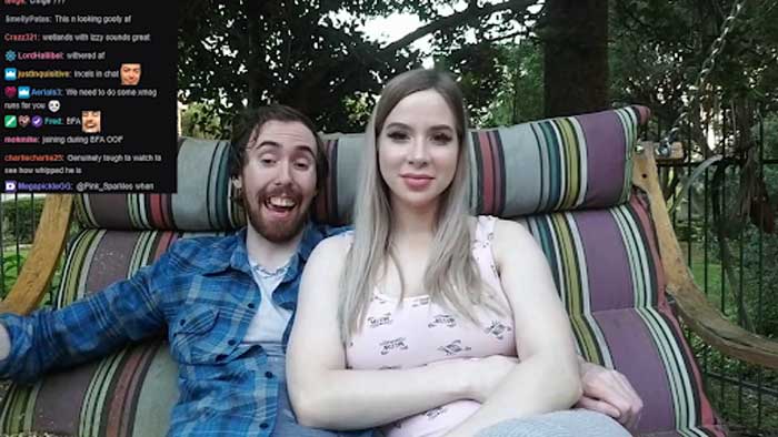 Pink Sparkles and Asmongold sitting on a couch in their backyard