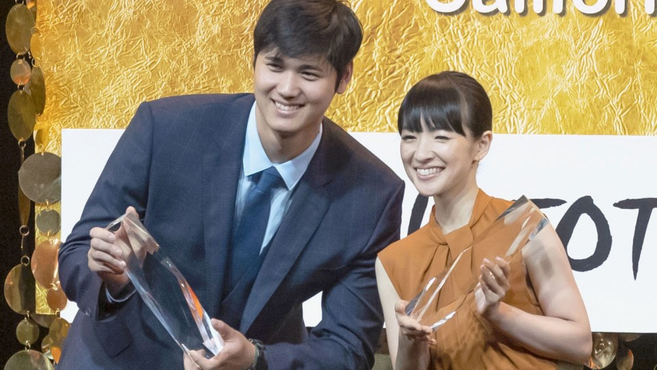 Shohei Ohtani and a girl posing with trophy