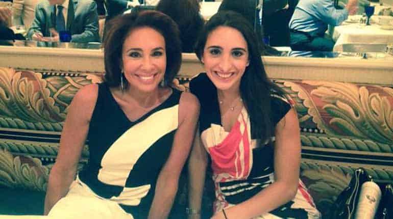 Christi Pirro wearing a black and white dress while sitting with her friend who is wearing a pink and black dress