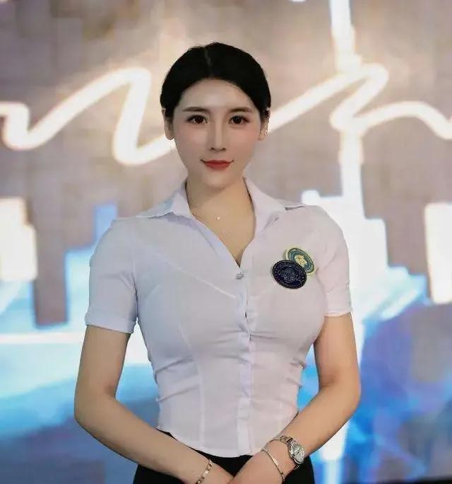 Liu Tai yang in the white and black dress looks with her hair tied up and with a professional smile