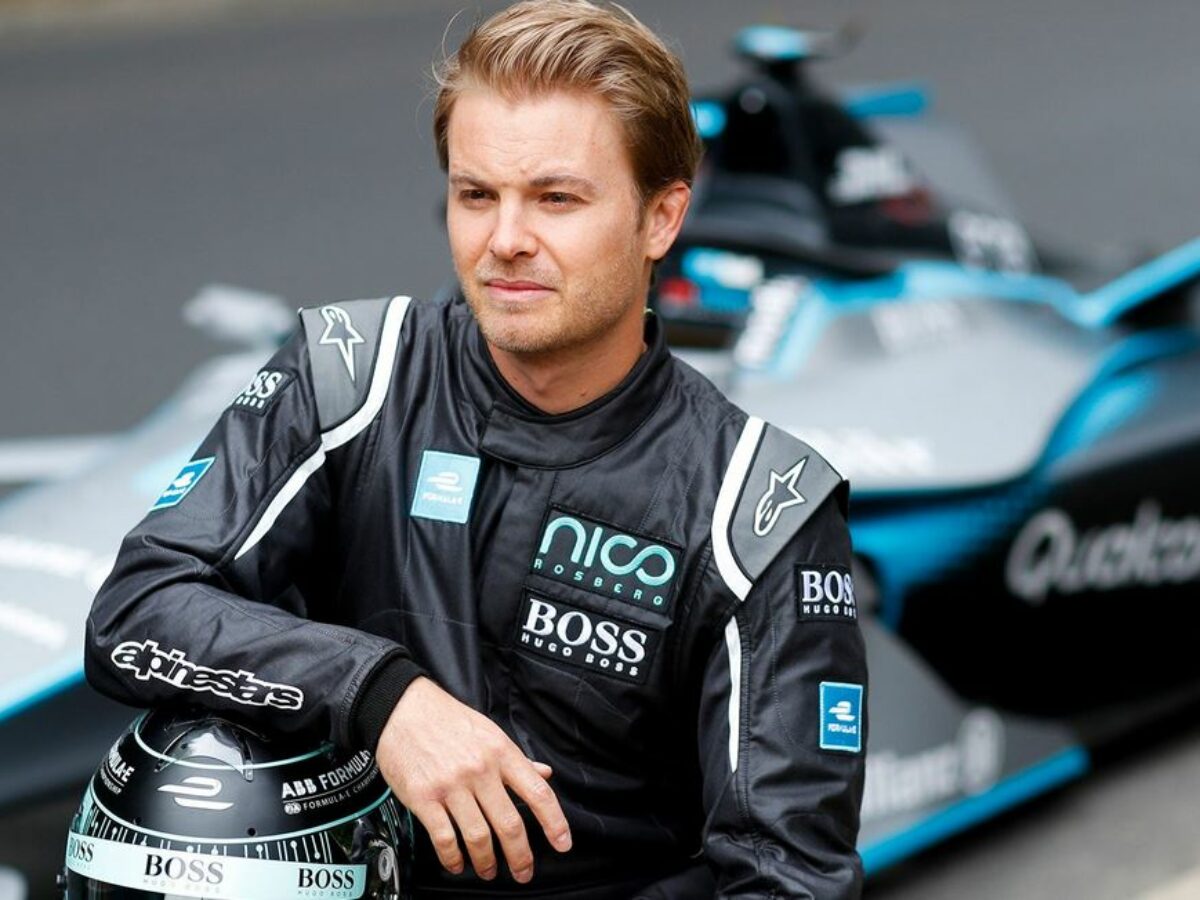 Nico Rosberg wearing a black jacket and resting his arms on a black helmet