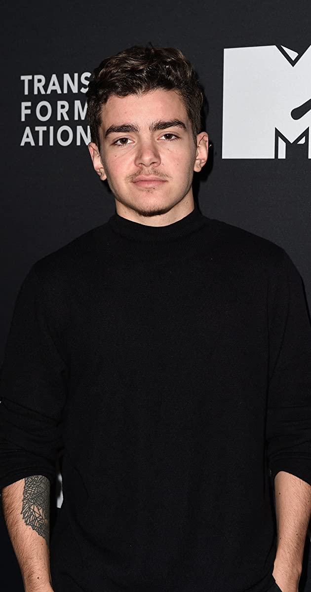 Elliot Fletcher wearing a black shirt and standing with hands in his pockets