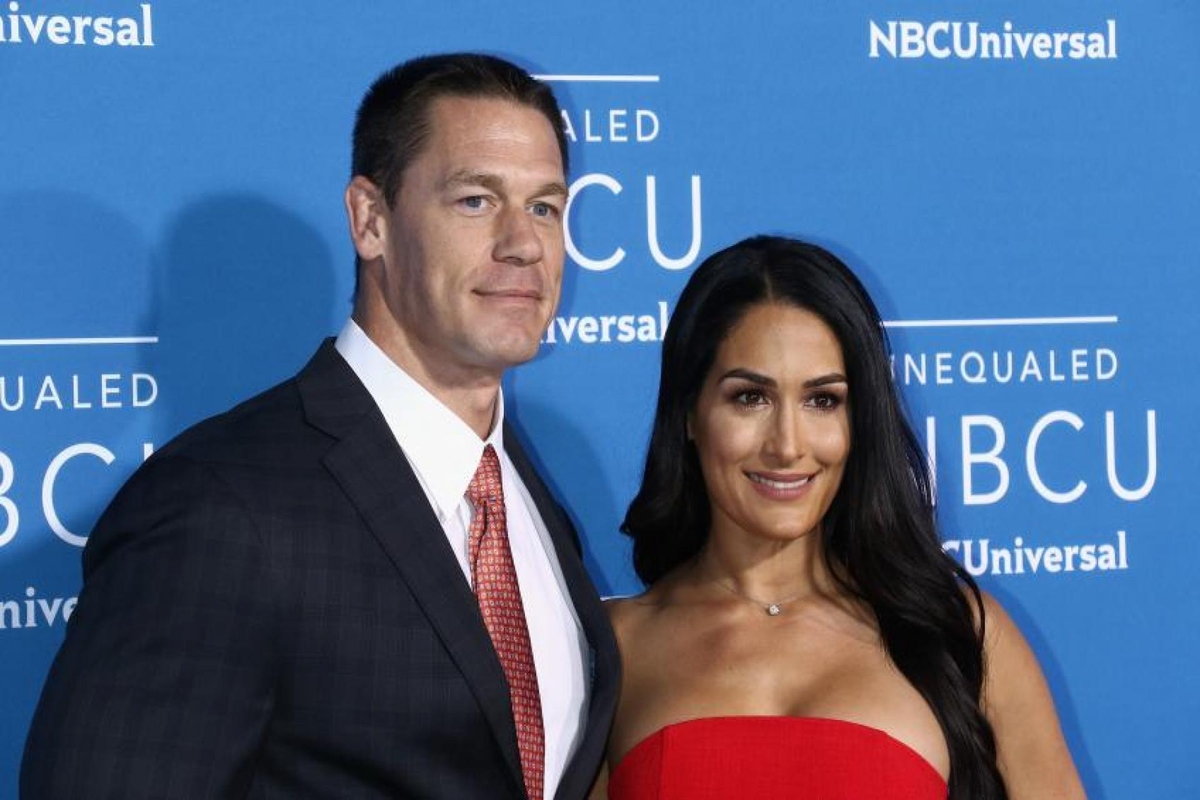 John Cena in a black suit and Elizabeth Huberdeau in a red dress