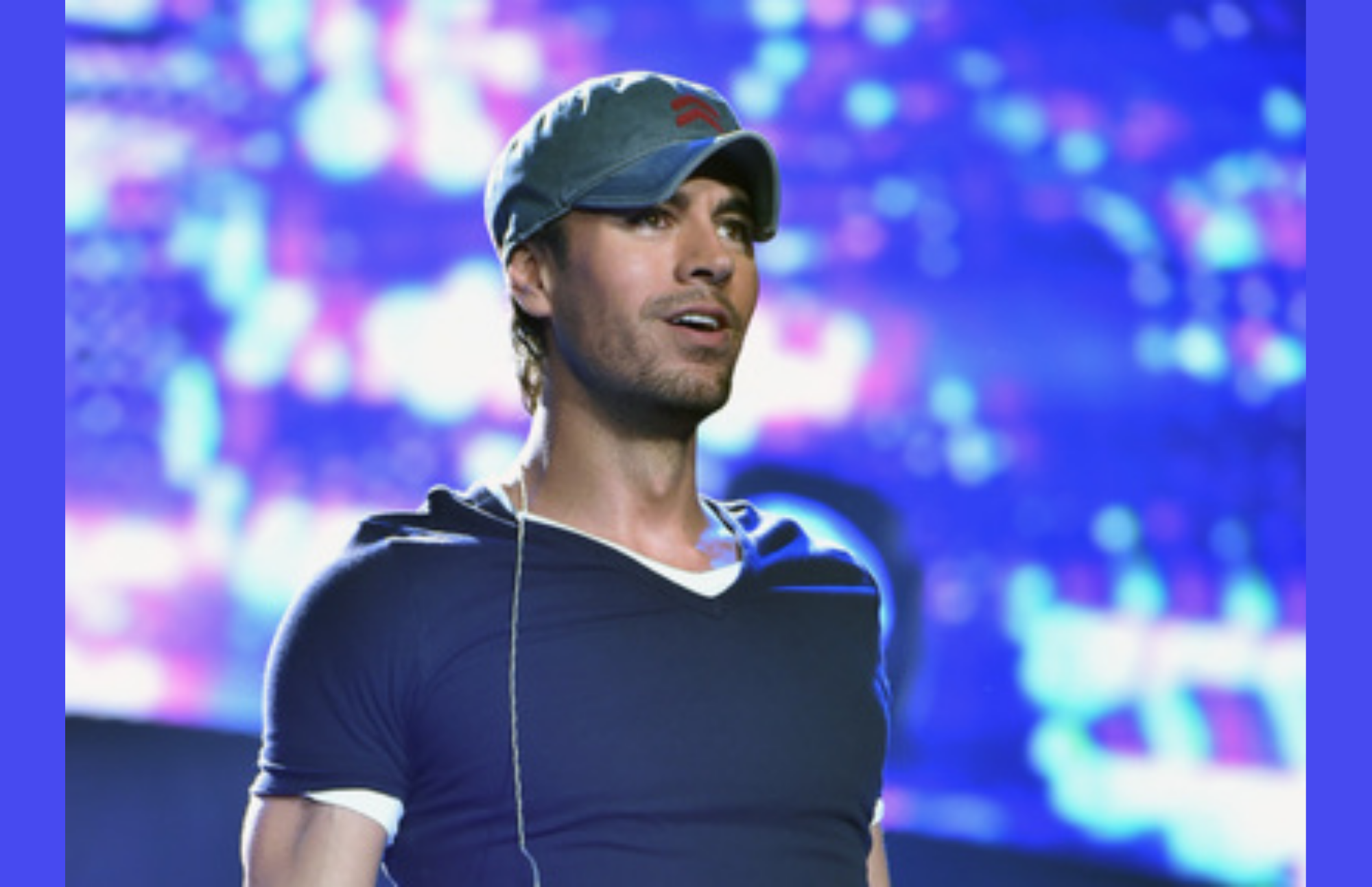 Enrique Iglesias performs in a navy blue shirt and a cap