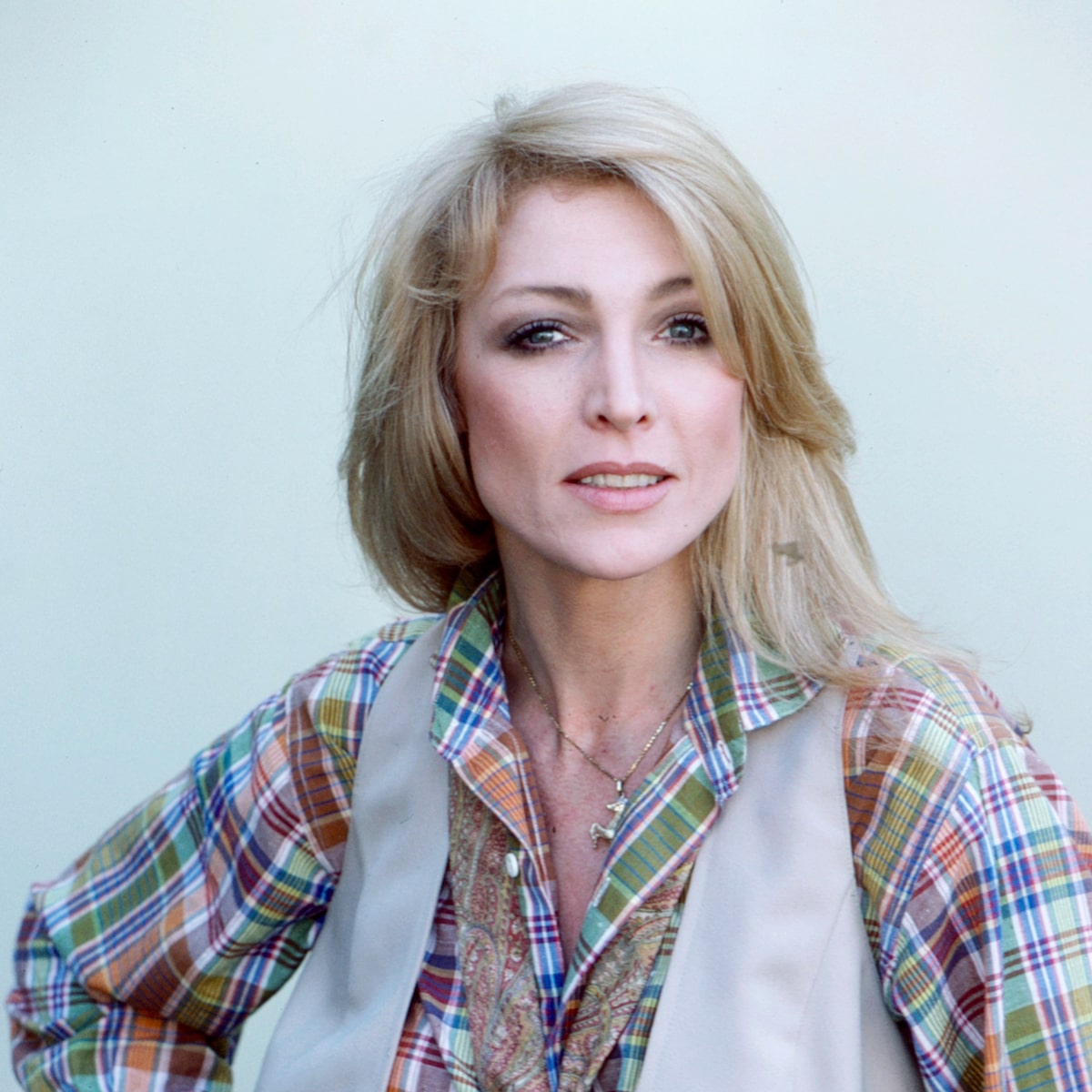 Joanna Pettet wearing colorful shirt with blond hair and a golden necklace