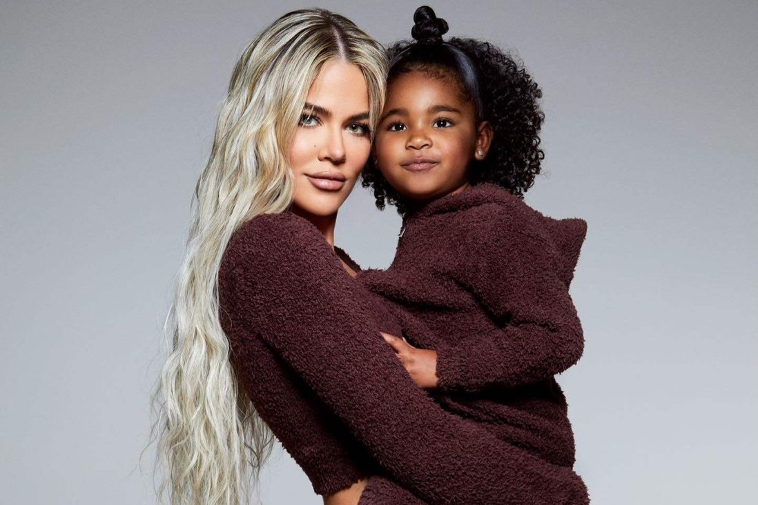 Khloe holding true in her arms withe their matching maroon sweater