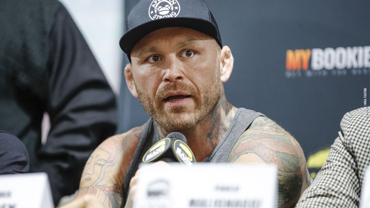Chris Leben with a black cap and a microphone