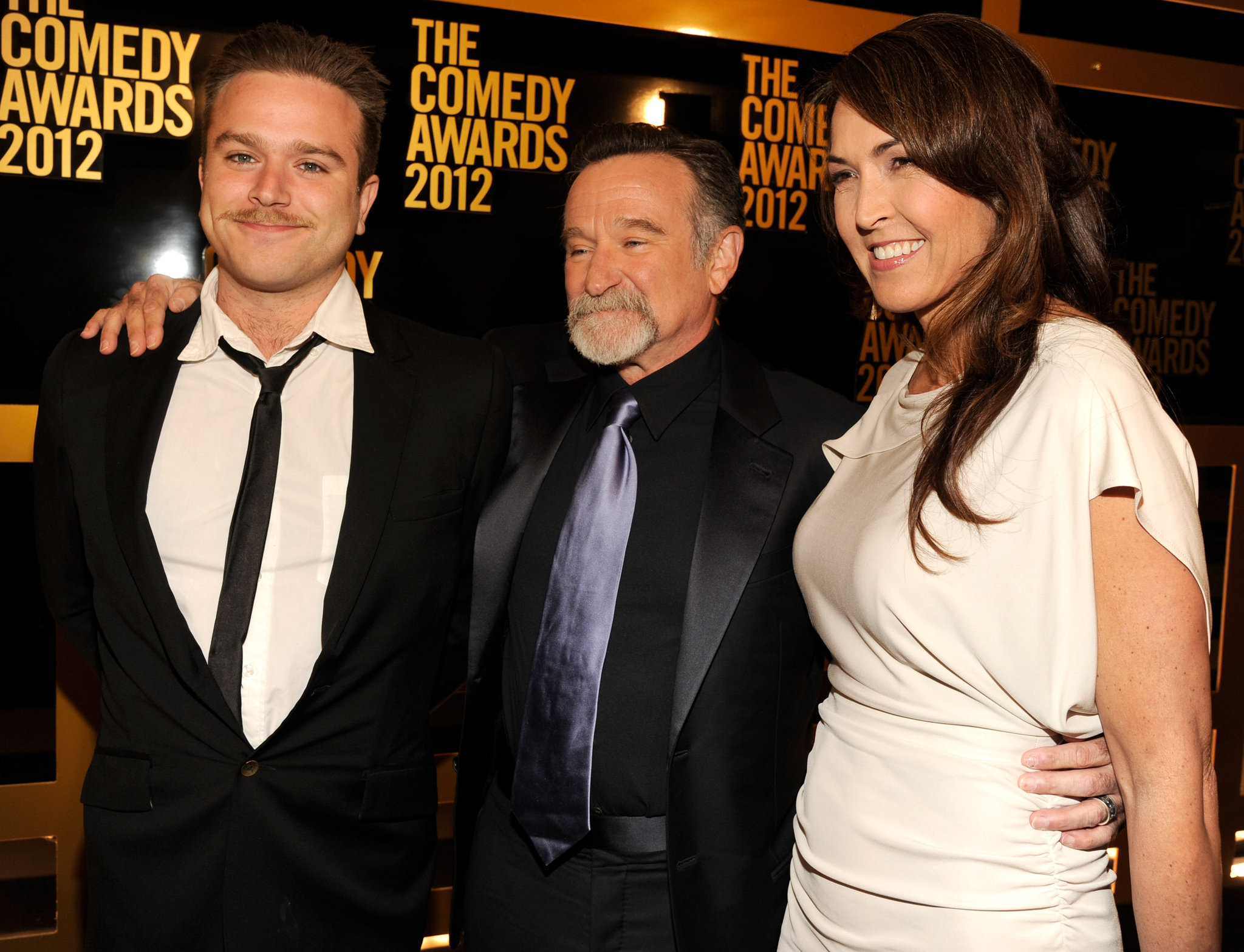 Robin Williams standing with his wife and son at an award show