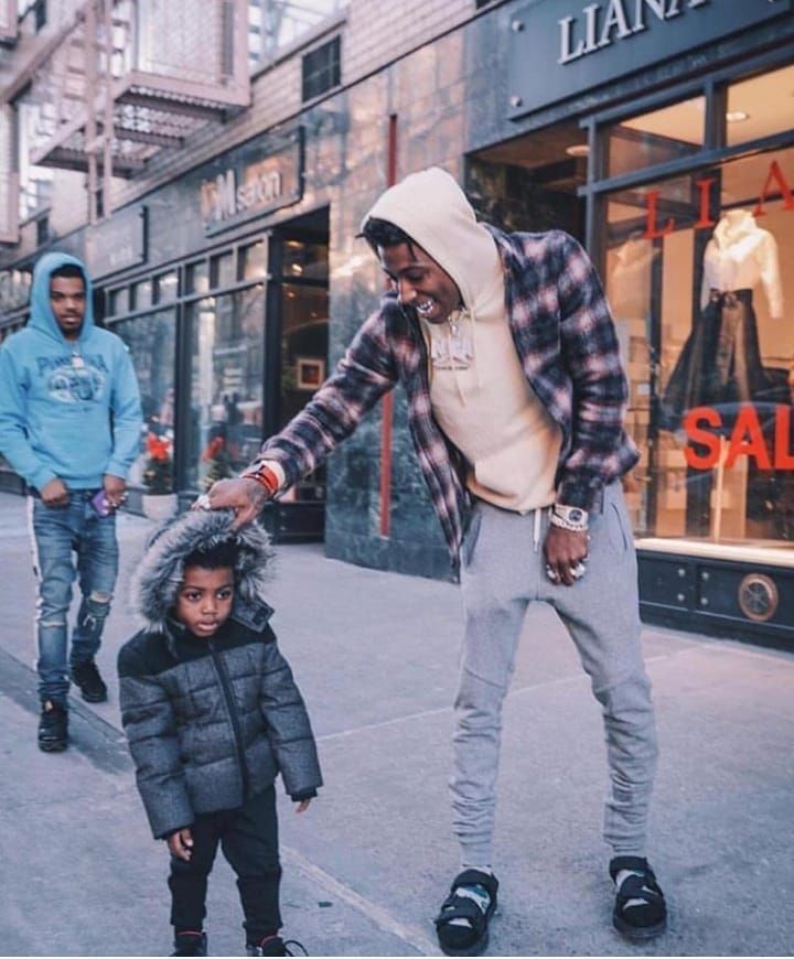 Kayden Gaulden standing with father where he is fixing his hoodie on a street