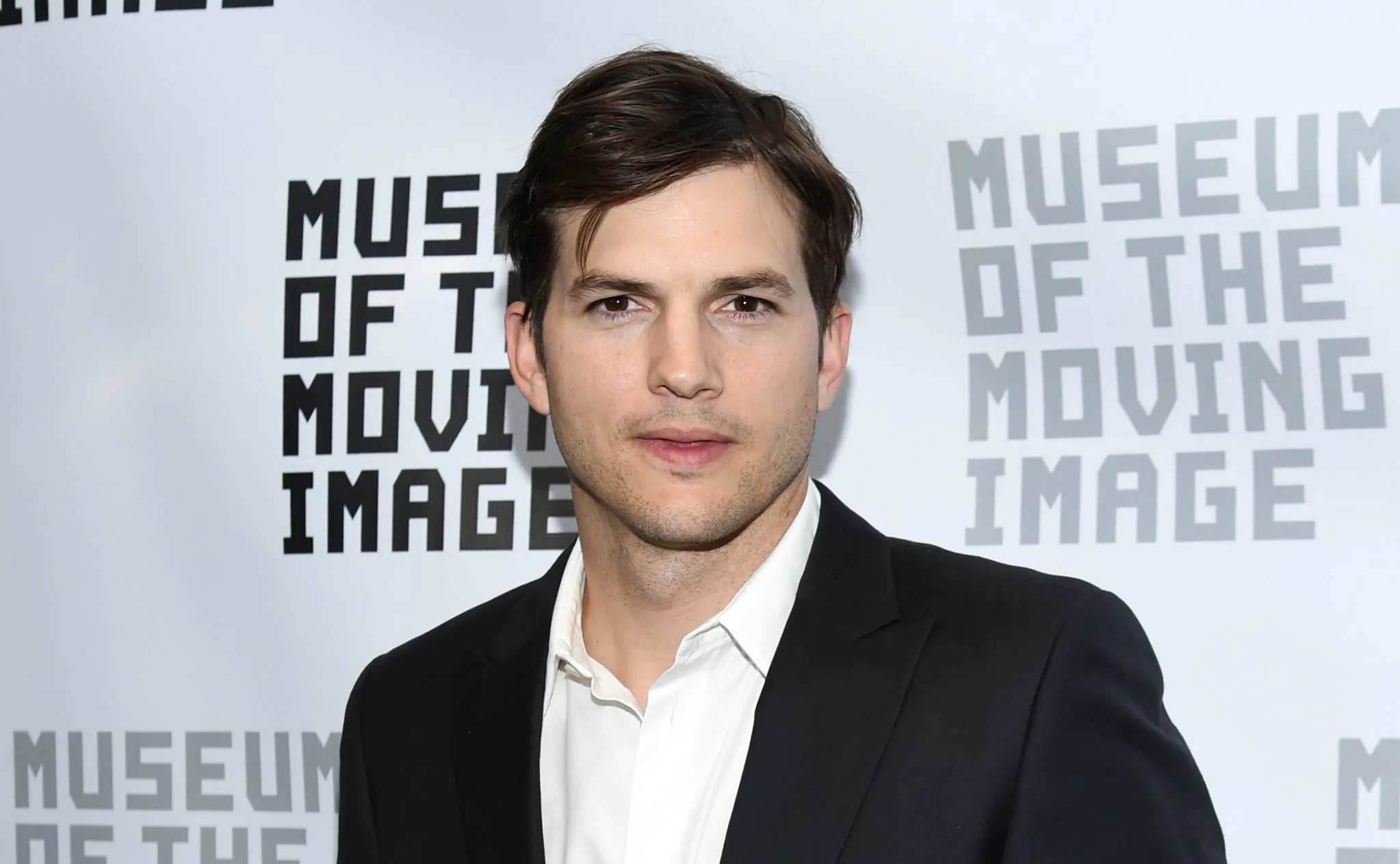 Ashton Kutcher wearing a black suit at Museum of the Moving Image
