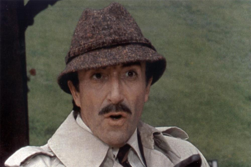 Peter Sellers wearing a trench ocat and hat