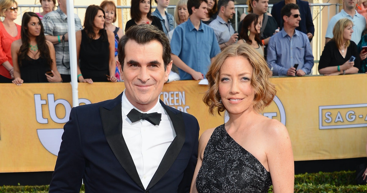 Ty Burrell smiling in a black coat with a black bow tie and Holly Burrell smiling in a black and silver glittery dress