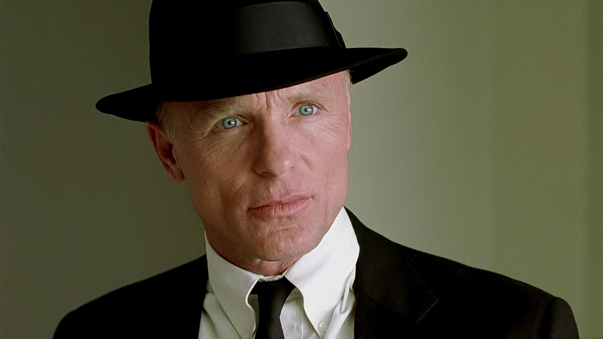 Ed Harris wearing a suit and black hat