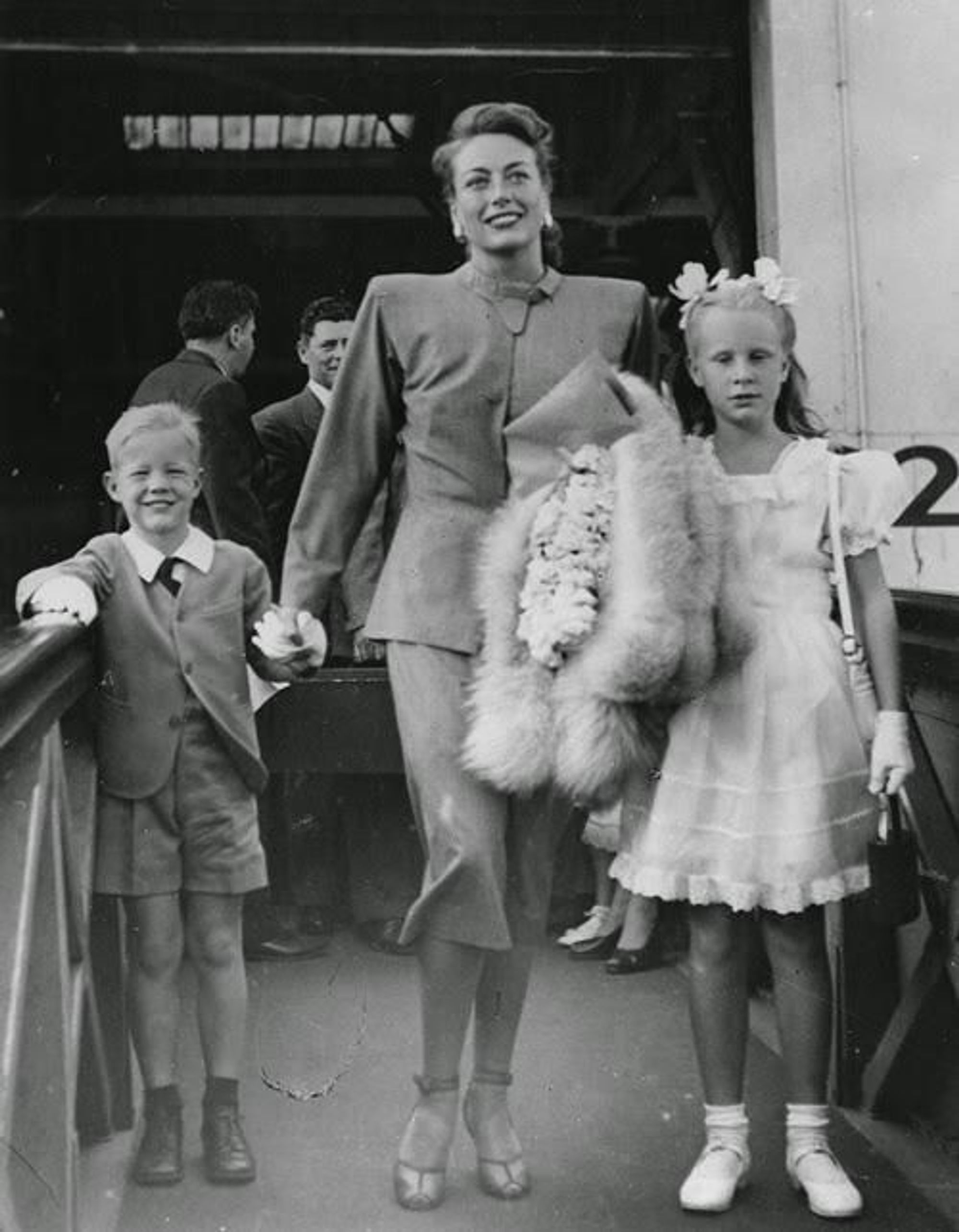 Christopher Crawford, Joan Crawford, and Cristina Crawford smiling while walking