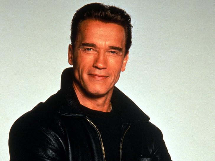 Arnold Schwarzenegger smiling while wearing black shirt and jacket