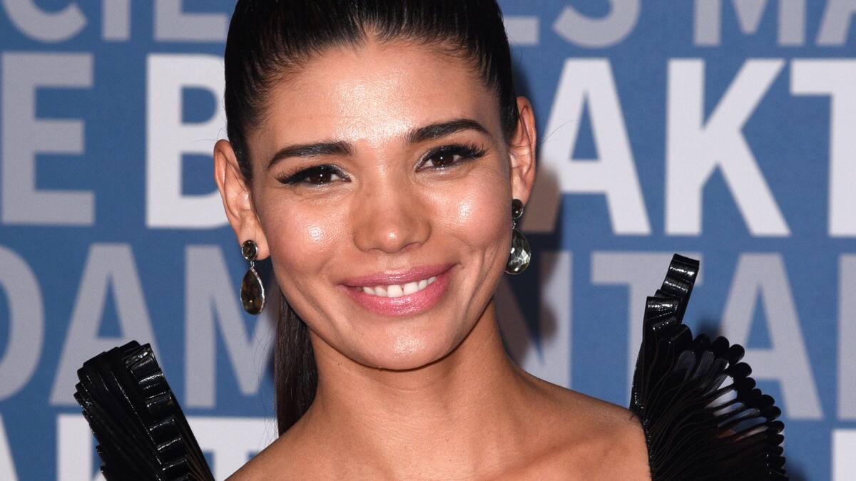 Paloma Jimenez smiling while wearing a black attire and black earrings