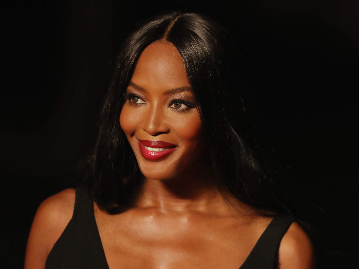 Naomi Campbell wearing a black dress and red lipstick