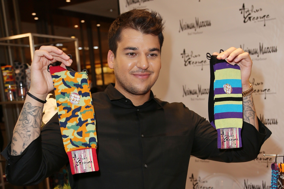 Rob Kardashian in black long sleeves while holding two different socks