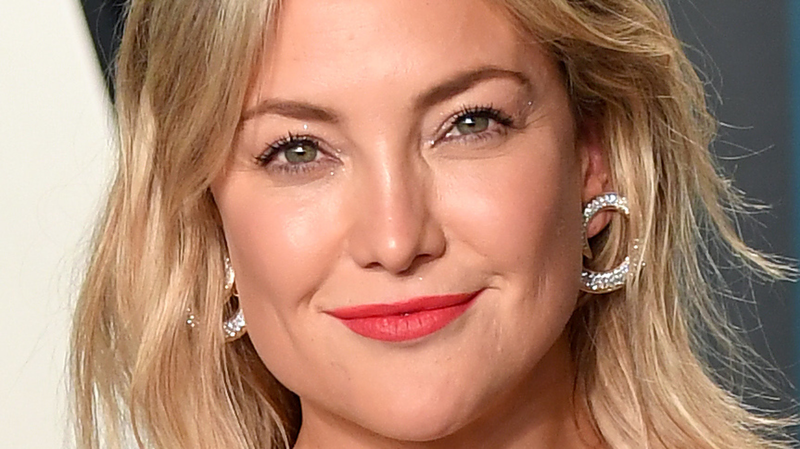 Kate Hudson wearing a red lipstick and spiral diamond earrings