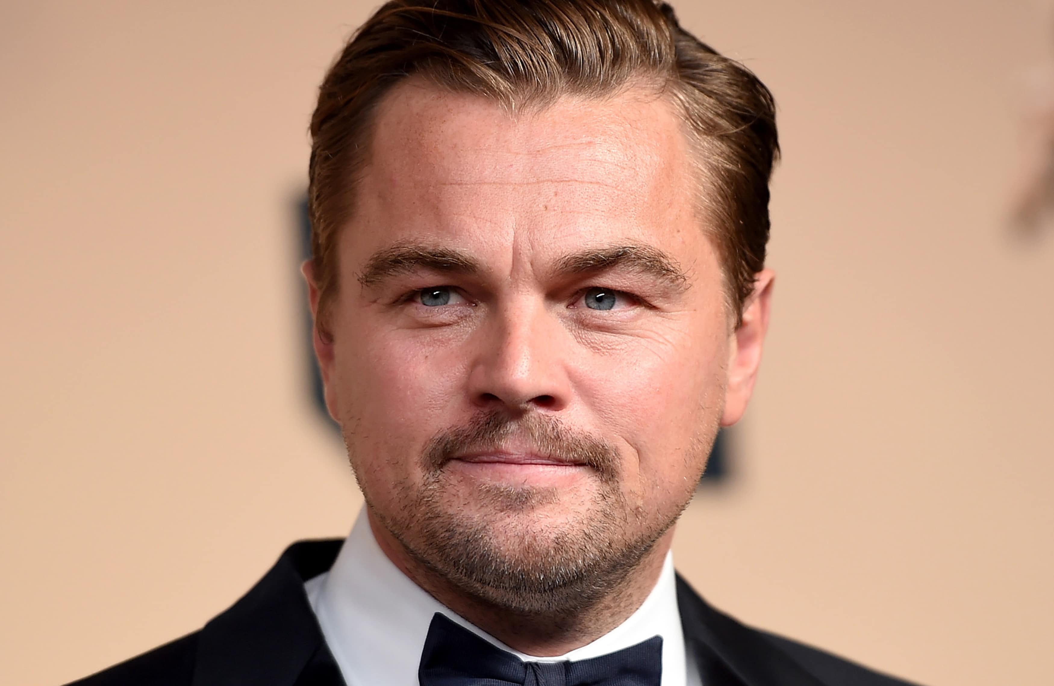 Leonardo DiCaprio wearing a black three piece suit