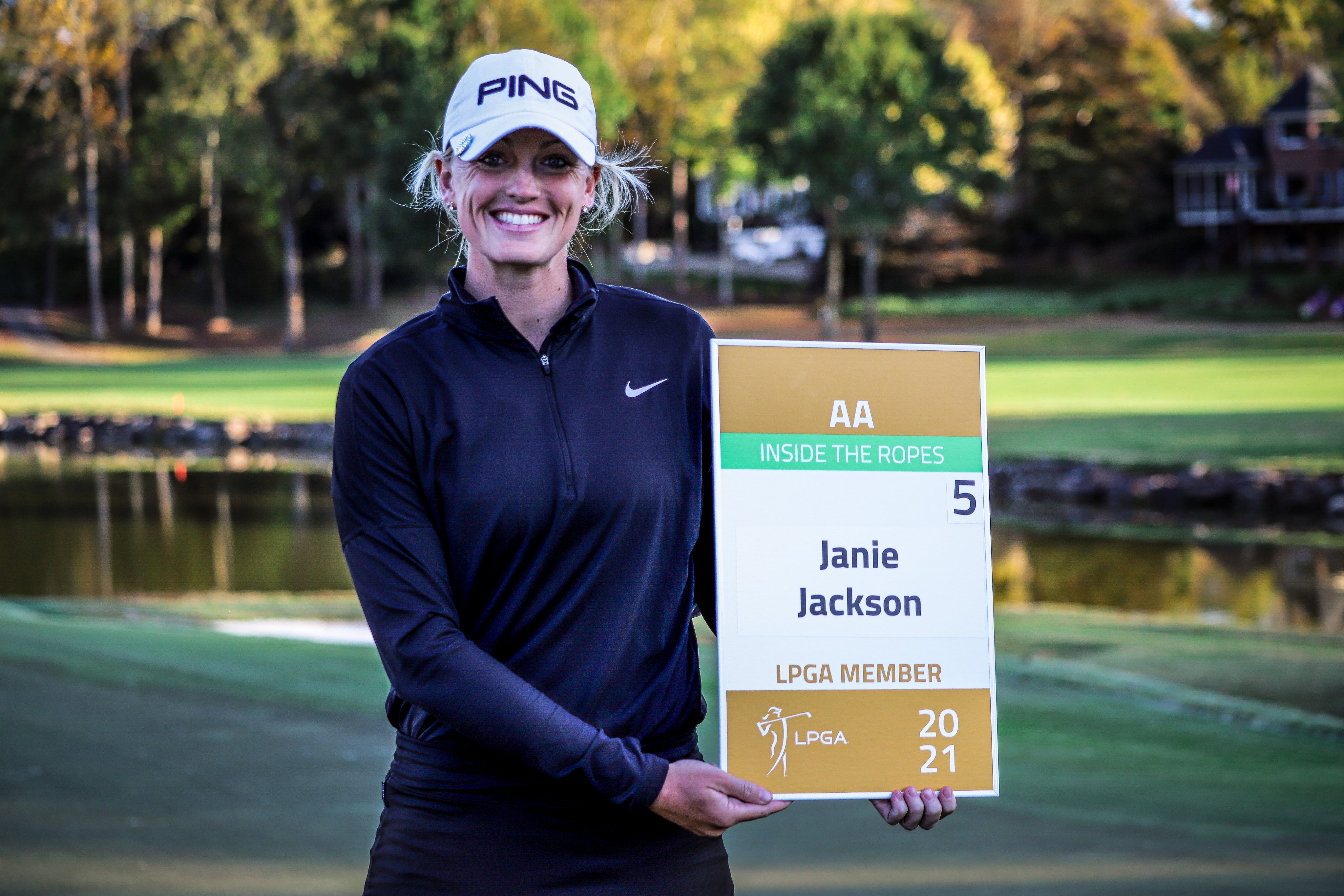 Janie Jackson posing with a sign that mentions her name as an LPGA Member