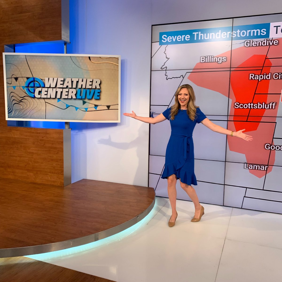 Colleen Coyle wearing a blue dress during her live weather broadcast