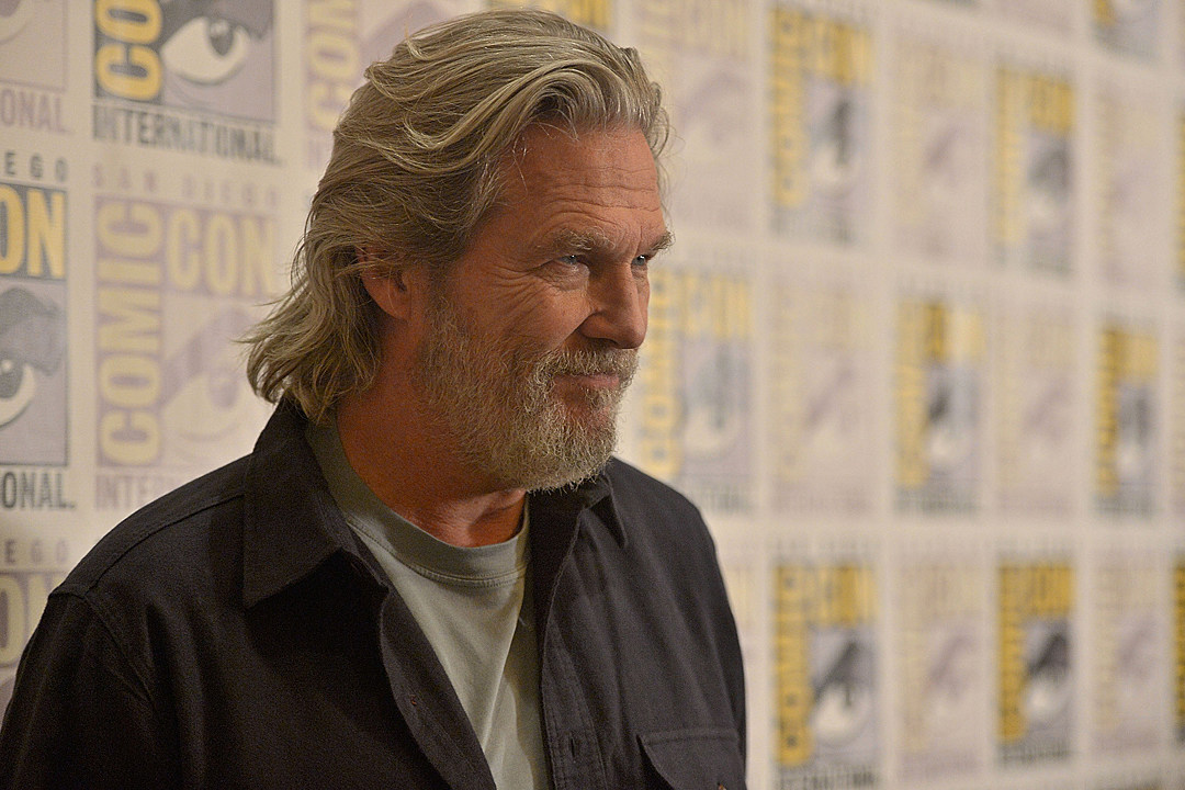 Smilling Jeff Bridges in a green shirt and black polo