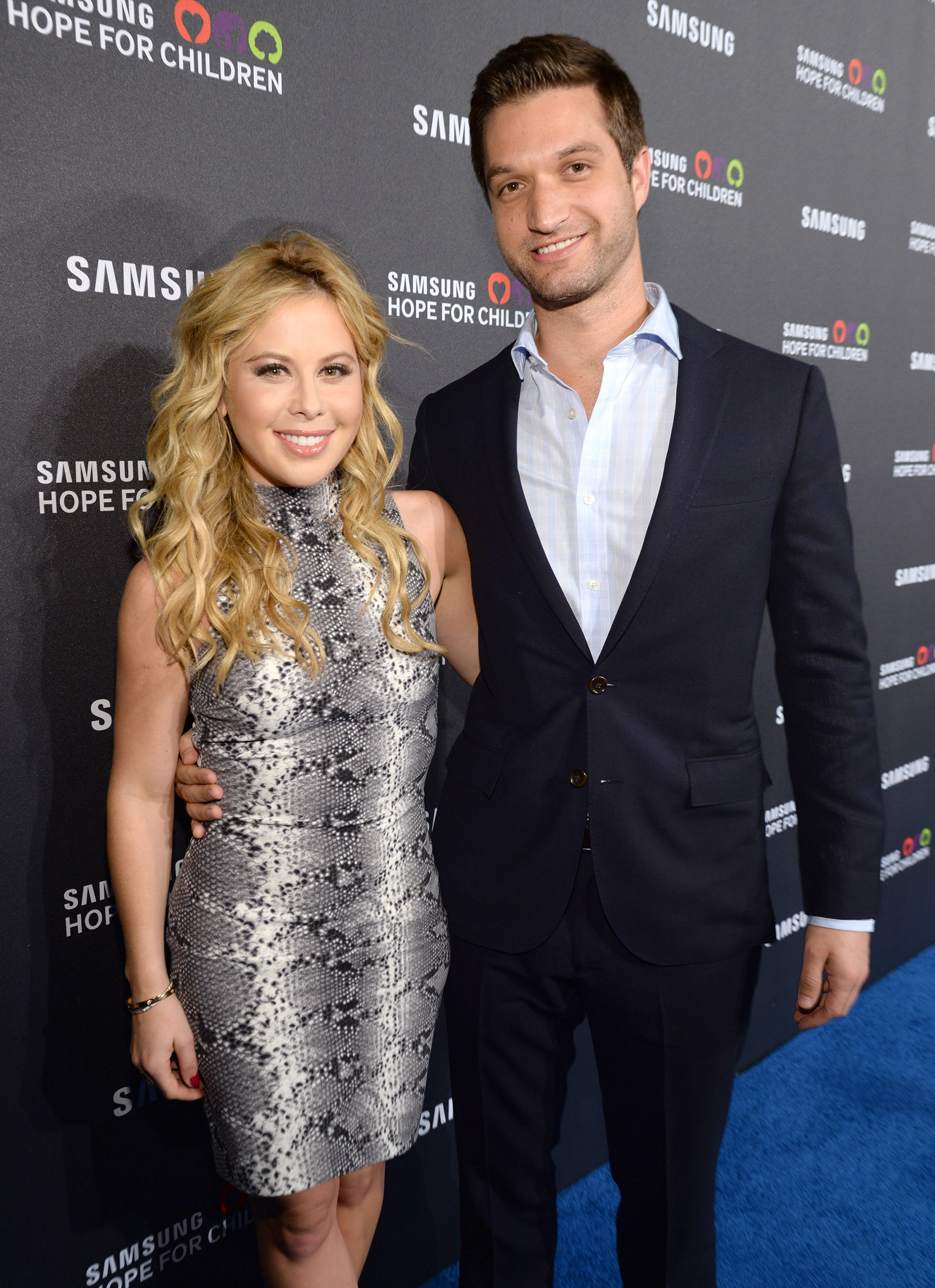 Todd Kapostasy with Tara Lipinski in an event both smiling and dressed nicely