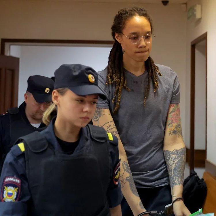 Female Russian police officer escorts a handcuffed Brittney Griner to her prison cell after a trial