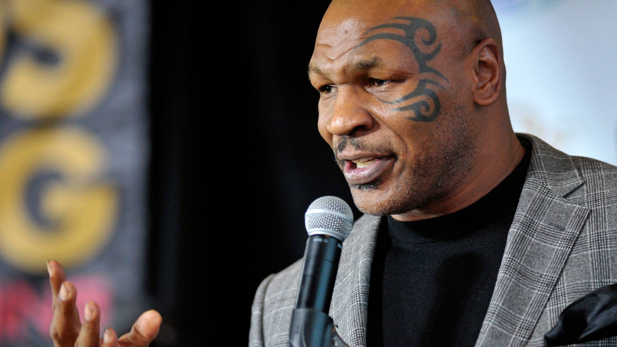 Mike Tyson Talking with a mic, his face tattoo is visible