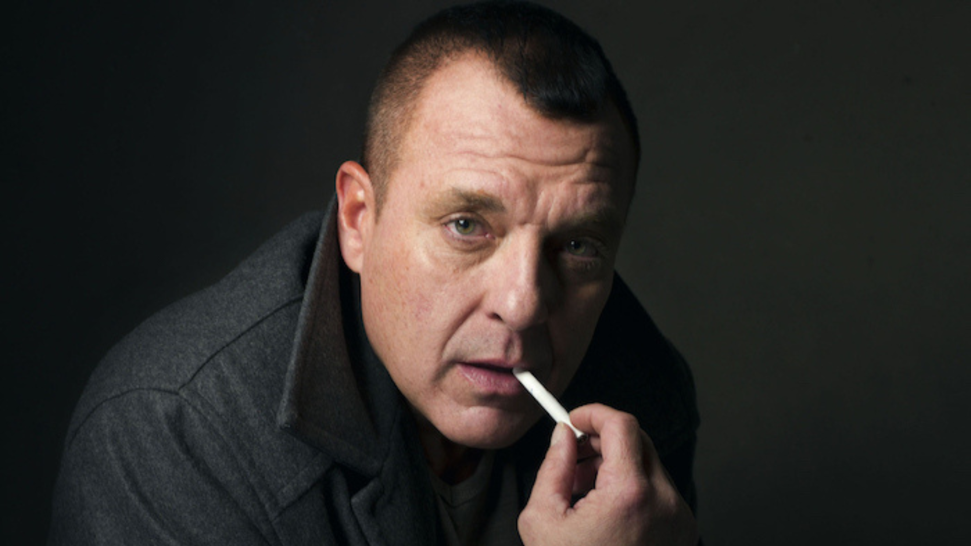 Tom Sizemore wearing black coat with a cigarrete on his mouth