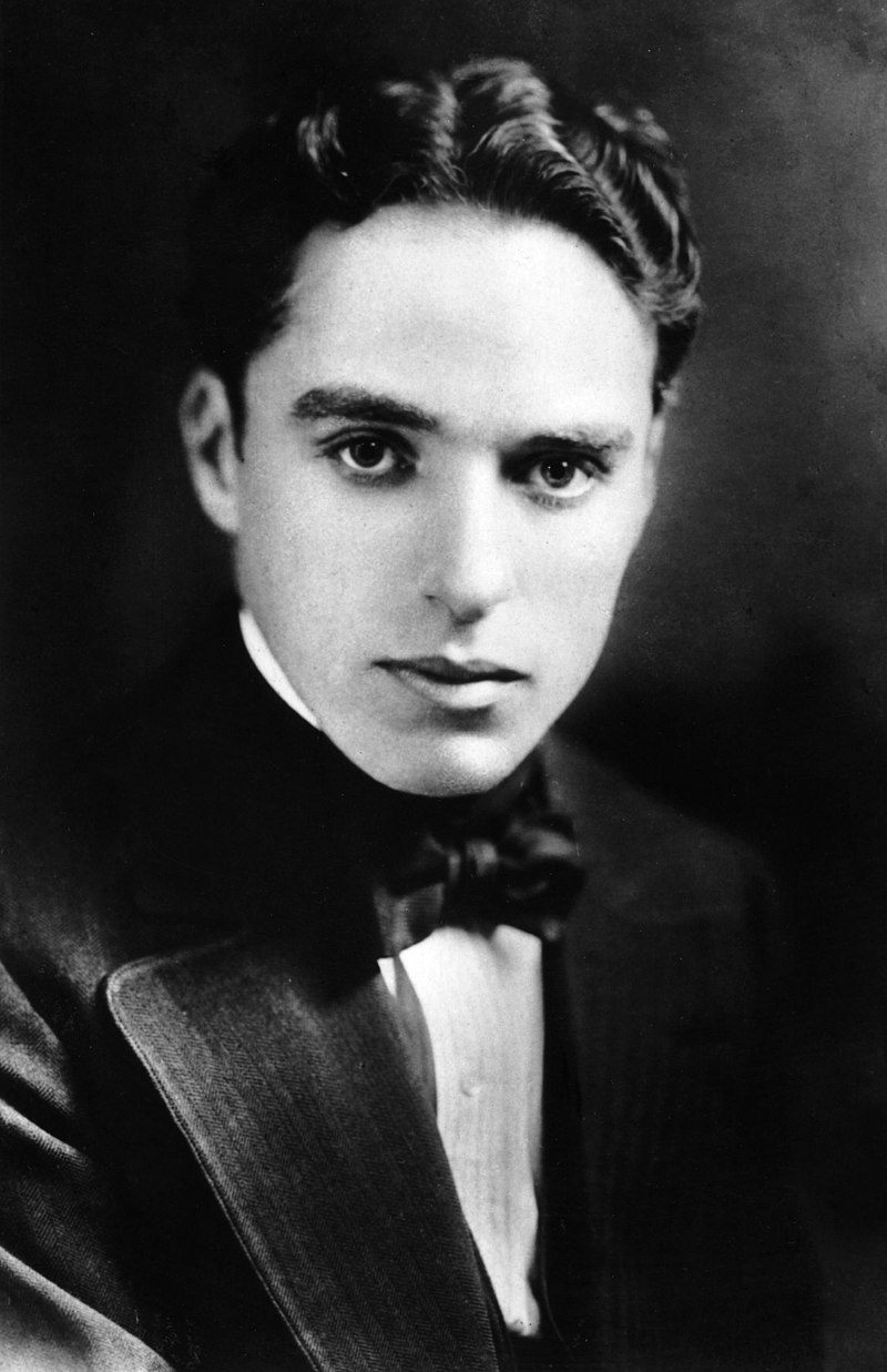 Charlie Chaplin at a younger age wearing a bow and coat