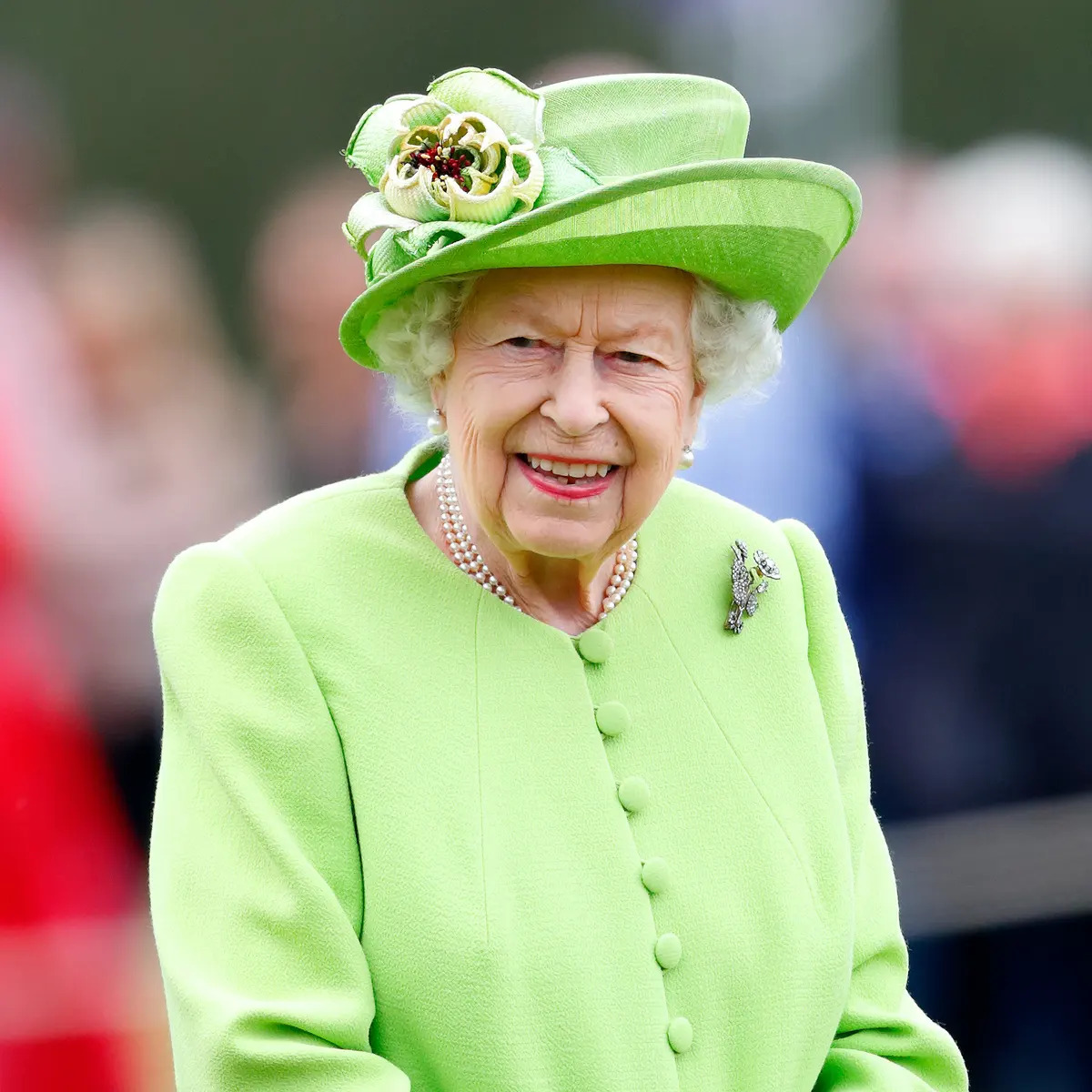 Queen Elizabeth wearing a yellow green outfit during her Platinum Jubilee celebration