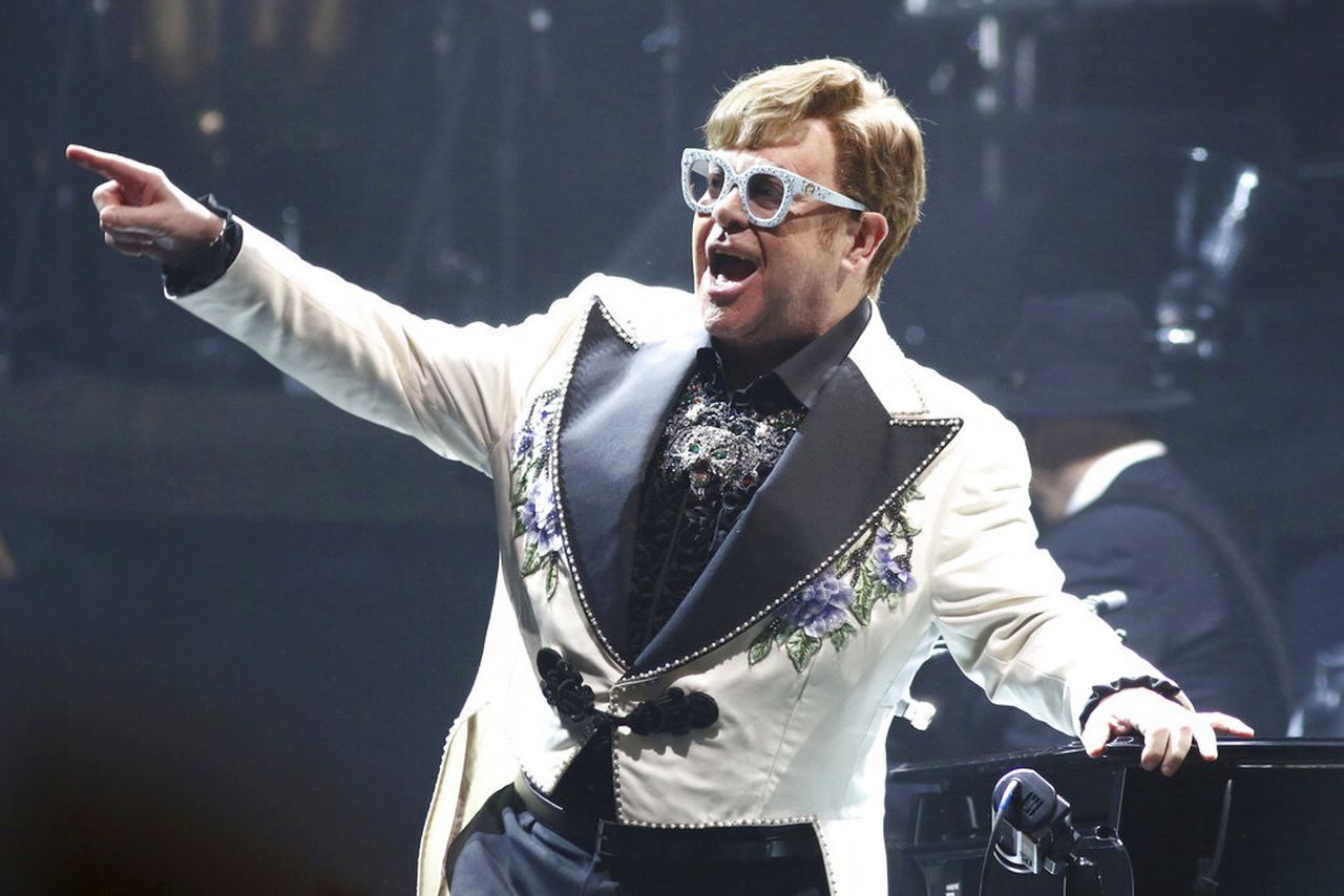 Elton John performing on stage pointing to the crowd
