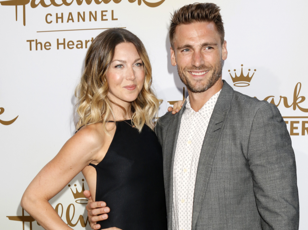 Andrew Walker wearing a grey suit with Cassandra Troy wearing a black dress at a Hallmark gala night