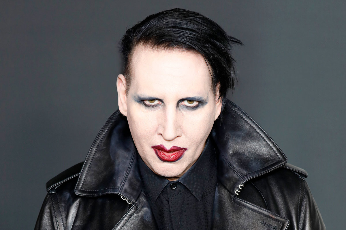 Marilyn Manson wearing a black leather jacket and black and blue eyeshadow