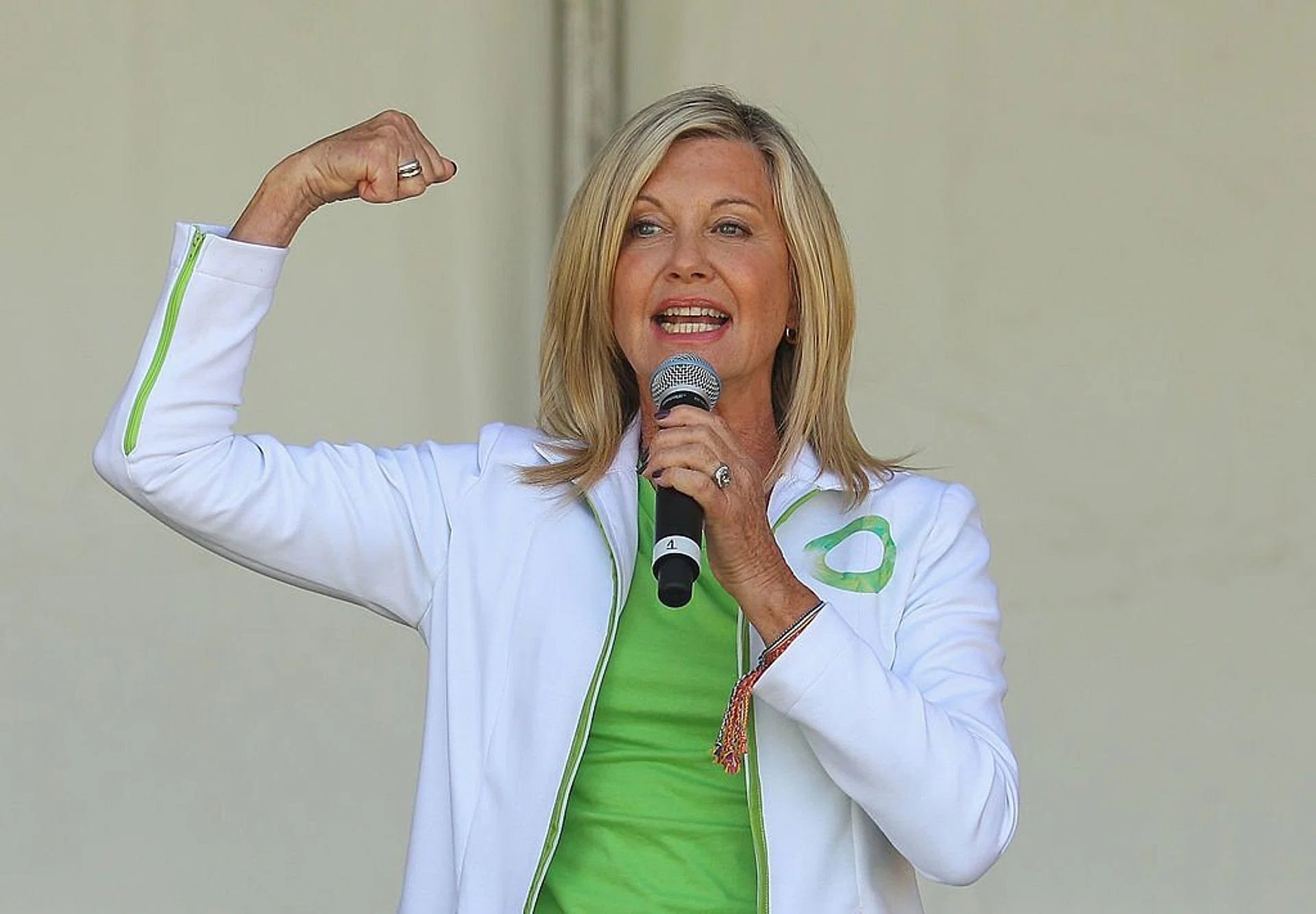 Olivia Newton-John Talking while flexing her right arm up