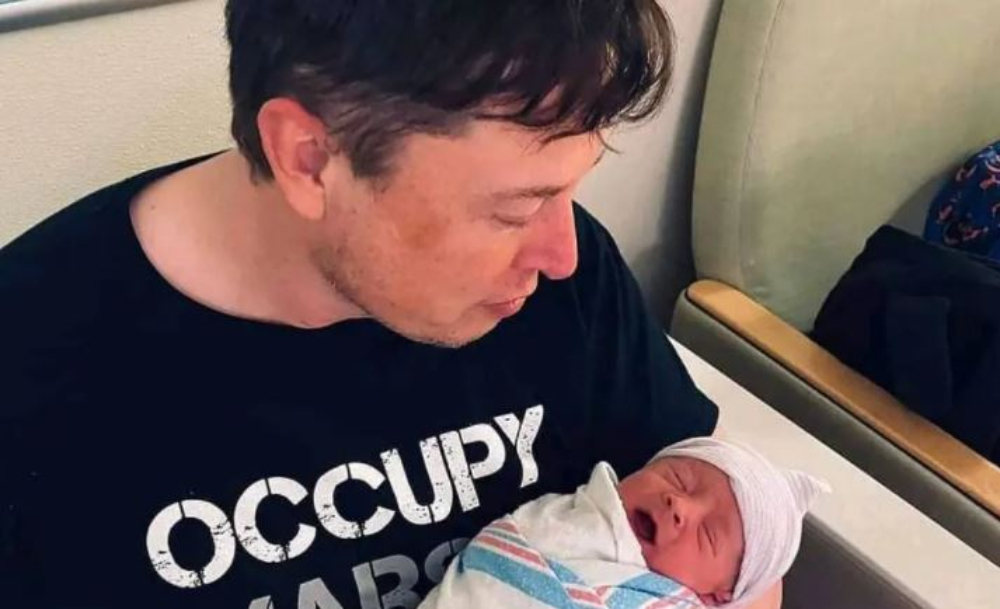 Elon Musk holding his newborn child