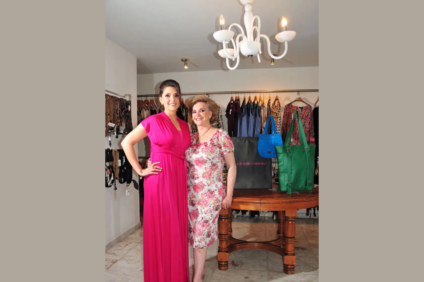 Alejandra Fernández wearing a pink dress beside a woman who are wearing floral pink dress inside the Alleza handbags shop