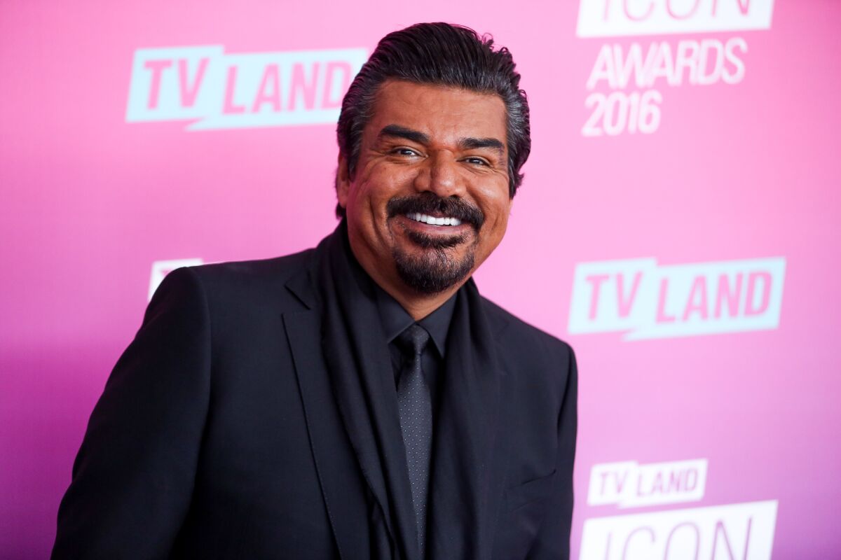 George Lopez smiling while wearing a suit